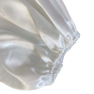 Détail des poignets élastiques bouffants sur une robe en satin blanc élégante