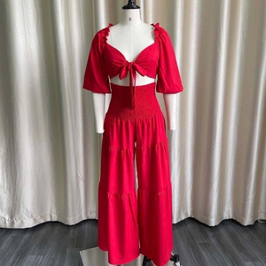 Detail of red two-piece set featuring a tie-front V-neck top and tiered wide-leg pants