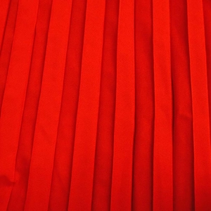 Gros plan détaillé de la texture plissée rouge vif sur cette robe longue à épaules nues