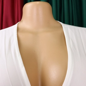 Détail du décolleté plongeant en V et du tissu élastique lisse sur la robe de soirée blanche