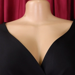 Detail view of the elegant deep V-neckline on a pleated black sexy evening party dress