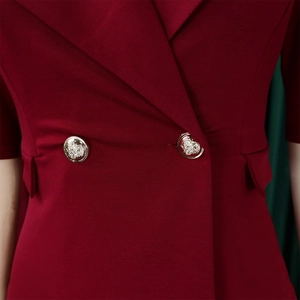 Gros plan d'une robe blazer rouge foncé avec boutons dorés gaufrés et col à revers