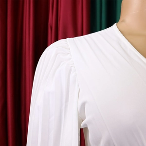 Vue détaillée d'une robe blanche à col en V avec des plis et des manches bouffantes