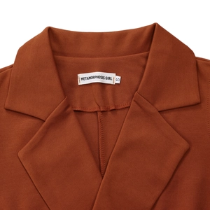 Detailed close-up of the notched lapel and woven size label on a brown sleeveless jumpsuit
