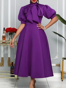 Elegant deep purple long dress with high neck bow tie and puffed sleeves in formal setting