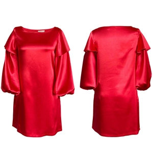Détail de la robe en satin rouge avec manches bouffantes et décolleté à volants