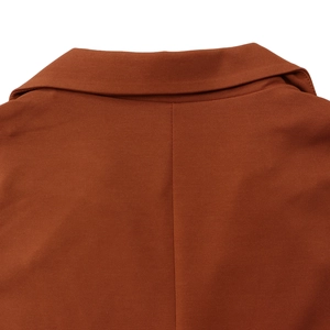 Close-up of rust-colored sleeveless jumpsuit featuring a notched lapel and fine fabric texture