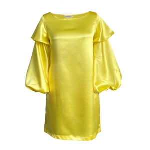 Détail du col d'une robe en satin jaune avec volants, manches bouffantes et étiquette