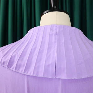 Détail de l'encolure plissée violette avec volants et texture de tissu lisse