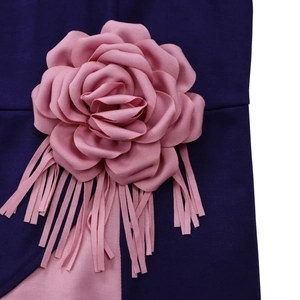 Detail of pink fabric rose and tassels on a purple pleated African dress garment