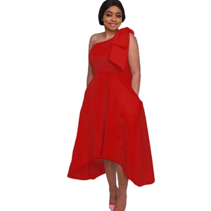 Détail d'une élégante robe rouge à une épaule avec un grand nœud et une coupe évasée