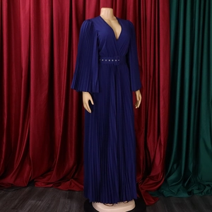 Détail d'une robe longue plissée bleu foncé avec col en V et manches cape à volants