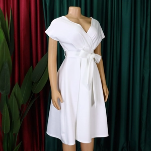 Detail of white V-neck wrap dress with waist-tie bow and elegant pleated texture