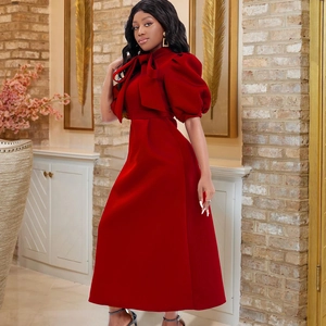 Dettaglio di un elegante abito midi rosso con grande fiocco e maniche a sbuffo