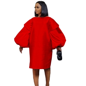 Détail d'une robe en satin rouge avec encolure dénudée et manches bouffantes élégantes