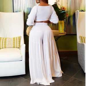 Detail of white two-piece crop top and layered wide-leg pants in breathable fabric
