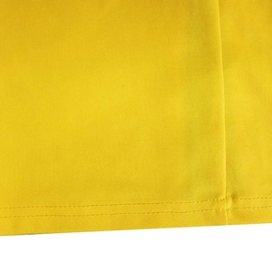 Gros plan détaillé du tissu jaune avec une finition soignée à double couture à l'ourlet