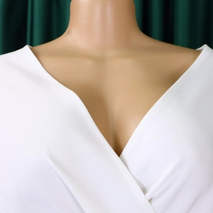 Detailed view of the deep V-neckline and high-quality white fabric on an evening dress