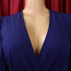 Détail du décolleté en V profond et des plis élégants aux épaules de la robe bleu foncé