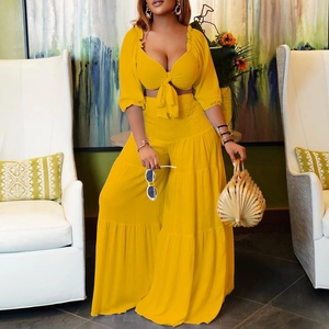Chic yellow two-piece set featuring a tie-up crop top and high-waist layered wide-leg pants