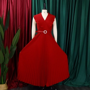 Détail d'une robe longue plissée rouge sans manches avec col V à volants et ceinture