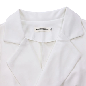 Detail of white notched lapel neckline with Metamorphosis Girl brand label and size S tag