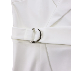 Detail of white jumpsuit waist belt with silver double D-rings and lapel collar texture