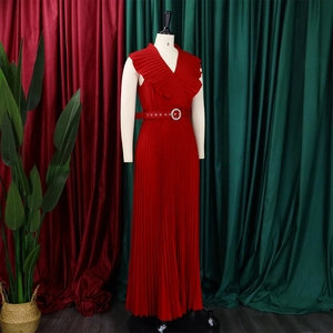 Détail d'une robe longue rouge à col en V avec bords à volants et boucle en strass