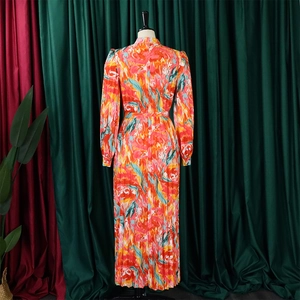 Detail of colorful abstract print and vertical pleated texture on long sleeve maxi dress
