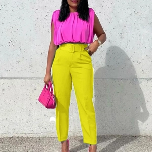 Women's pink pleated sleeveless top and yellow high-waisted dress pants set with belt
