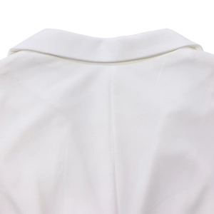 Detail shot of white sleeveless jumpsuit showing high-quality twill fabric texture and collar