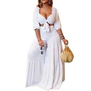 Detail view of white puffed sleeve crop top with lace-up front and wide-leg trousers
