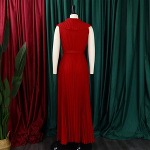 Détail d'une robe longue rouge plissée sans manches avec col à volants et ceinture assortie