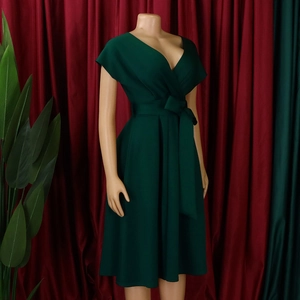 Detail of dark green V-neck dress featuring a cinched waist and matching wide belt strap