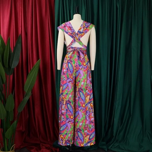 Detail of bohemian backless jumpsuit featuring colorful paisley print and crisscross straps