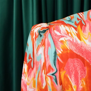 Detail of puffed shoulder and abstract marble print on long-sleeved dress