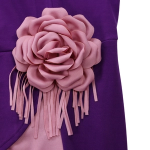 Detail of 3D pink fabric flower with long fringe on a purple pleated dress