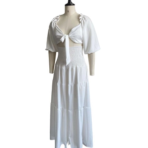 Close-up of white two-piece vacation set with puff sleeves and ruched skirt details