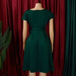 Detail view of the deep green short sleeve dress back with hidden zipper and waist belt