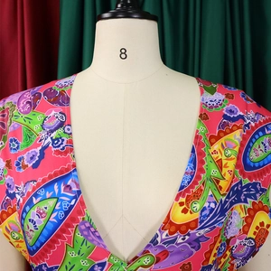 Detail of deep V-neckline featuring vibrant paisley and bohemian floral printed fabric