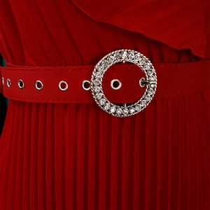 Détail macro de la robe plissée rouge avec ceinture et boucle ronde à strass étincelants