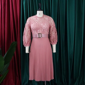 Detail of elegant lace hollow-out embroidery and vertical pleated skirt with a matching belt