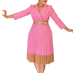 Detail eines eleganten Faltenkleids in Rosa mit braunem Saum und Taillengürtel