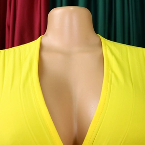 Détail d'un décolleté en V profond sur une robe jaune en tissu très élastique
