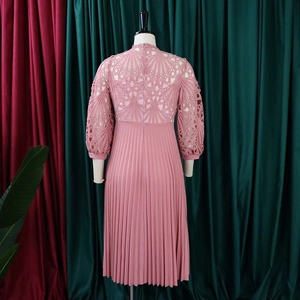 Detail of elegant dusty pink lace bodice and pleated skirt texture of the dress