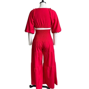 Detail of red two-piece set featuring smocked high waist pants and flared sleeve crop top
