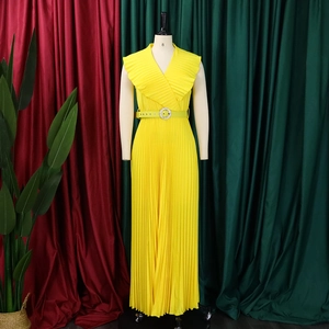 Détail de la robe longue plissée jaune avec décolleté en V et boucle de ceinture brillante