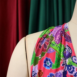 Close-up of vibrant tropical floral print fabric with fluid drape on a mannequin