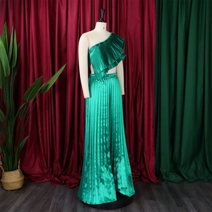 Detail of lime green pleated fabric texture and satin sheen on a two-piece set