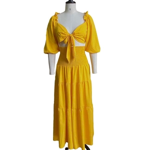 Detail of yellow two-piece tiered skirt set with smocked waist and tie-front crop top
